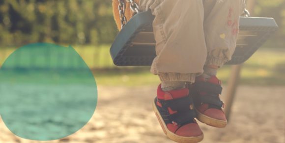 Kind schaukelt auf einem Spielplatz