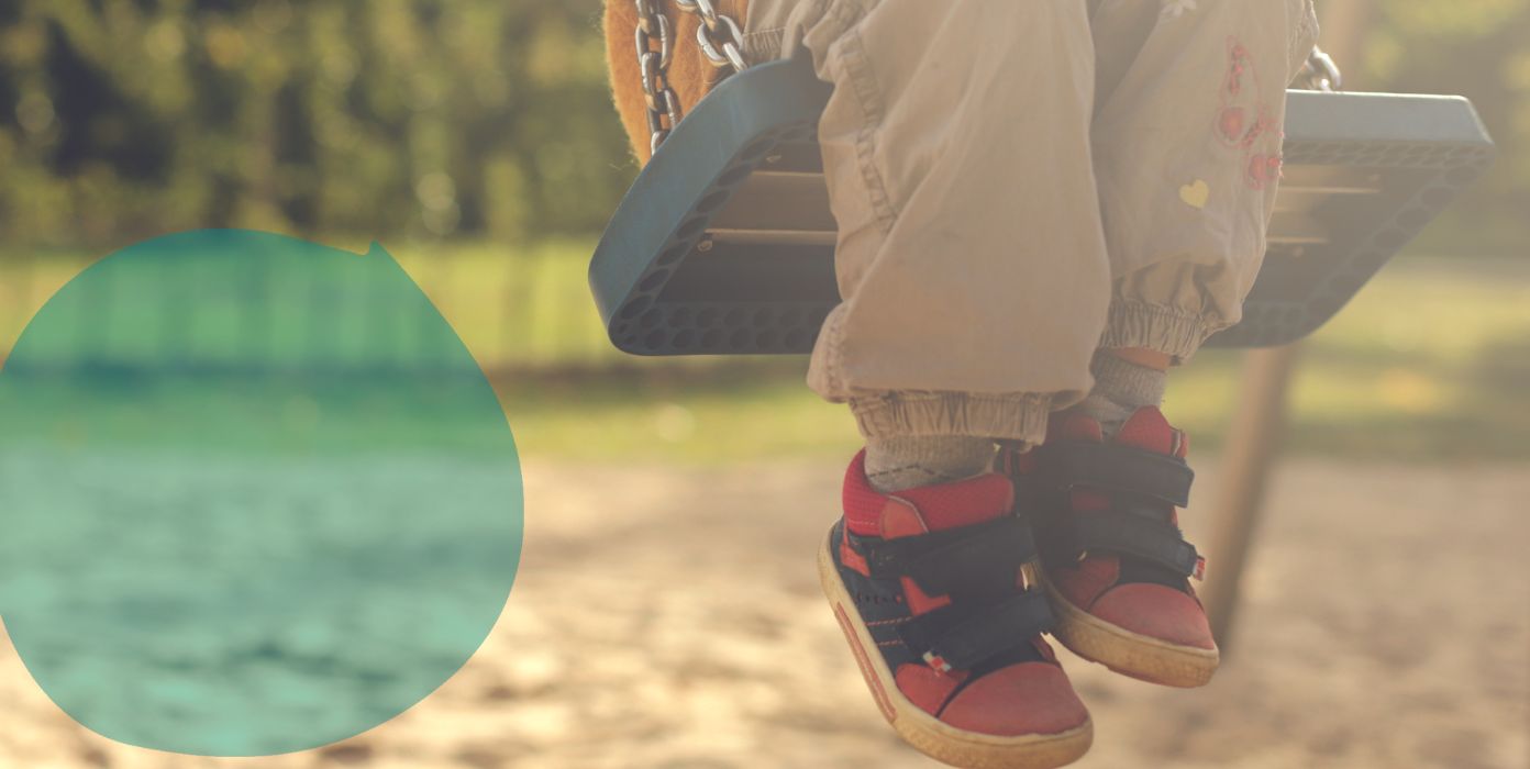 Kind schaukelt auf einem Spielplatz