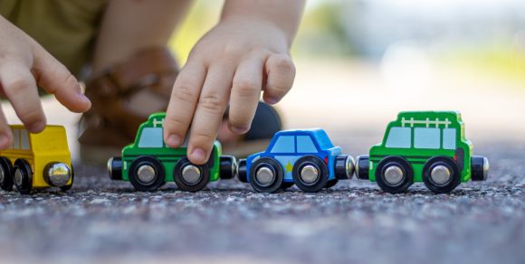 Kinderhände die mit einer Magneteisenbahn spielen