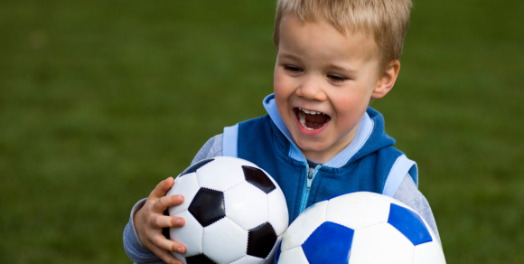 Junge mit Fußbällen