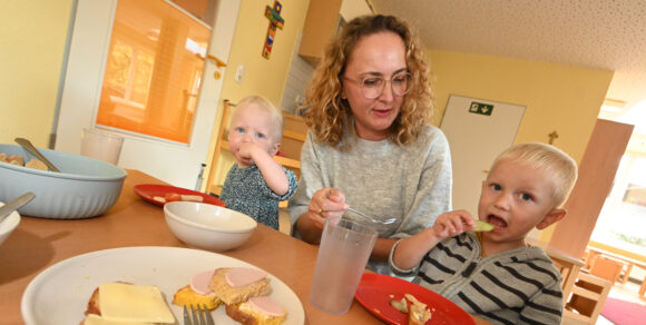 Frau mit zwei Kindern am Frühstückstisch