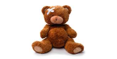 Ein Teddybär mit einem Pflaster am Kopf.