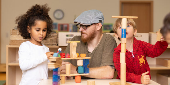 Patrick Lethen und zwei Kinder bauen mit Bausteinen.